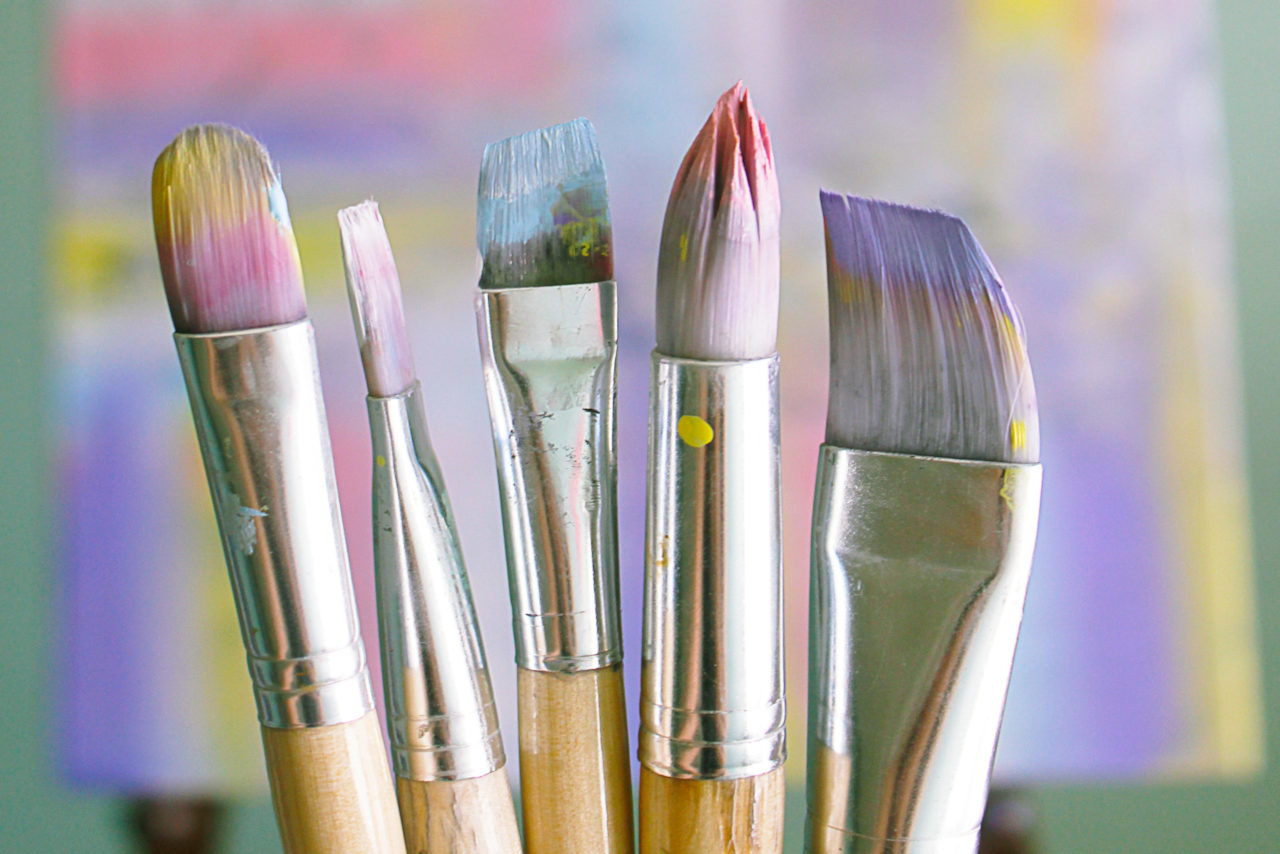 An assortment of paint brushes standing on end